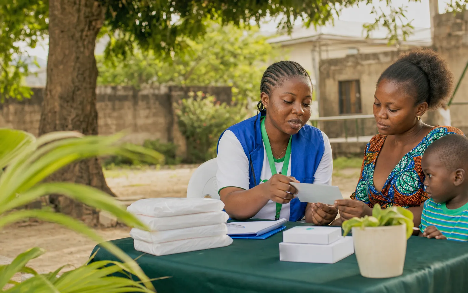 A doctor speaking with a mother and child during a home visit